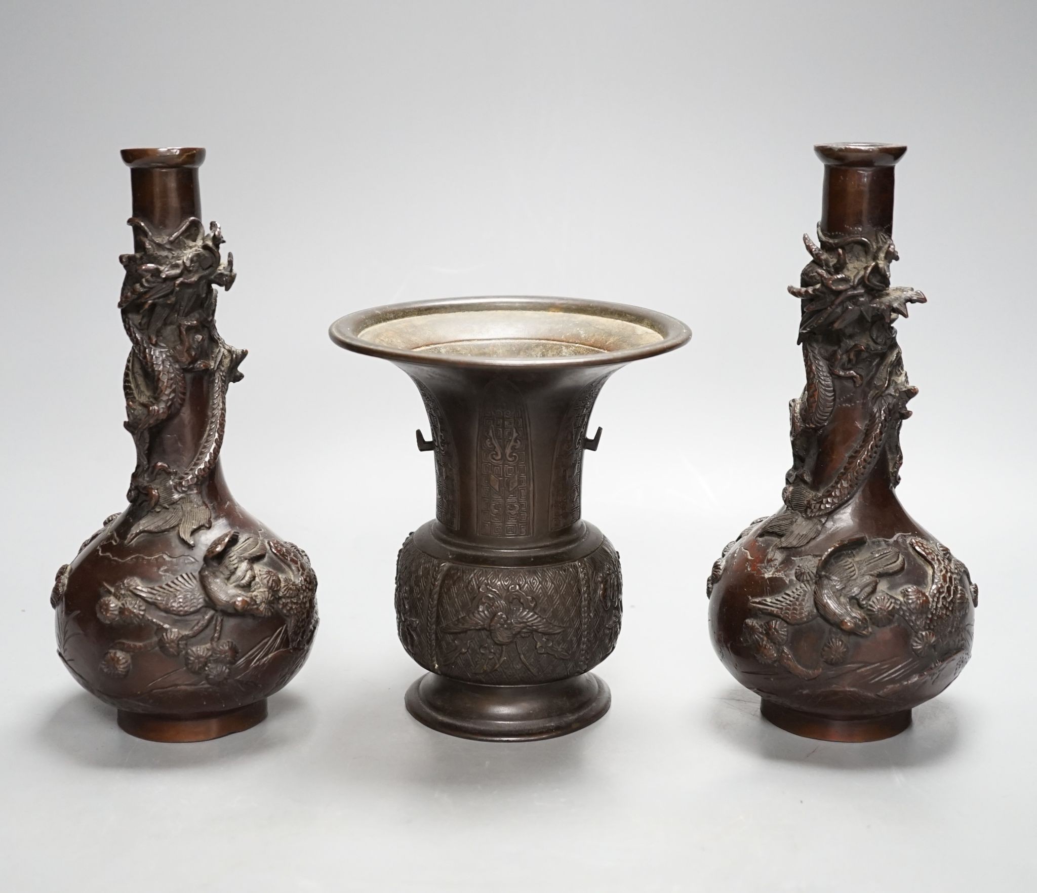 A pair of Japanese Meiji period bronze ‘dragon’ bottle vases and another, 21cm